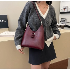 Detail of burgundy hobo bag with vintage patchwork stitching and silver buckle accent