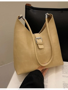 Retro beige underarm bag with geometric patchwork and silver buckles on books