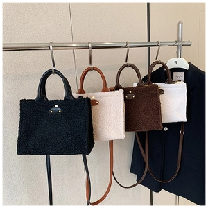 Close-up of four plush faux shearling handbags featuring leather handles and gold rivet tags