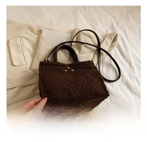 Brown faux shearling tote bag with leather handles shown on white bedding scene