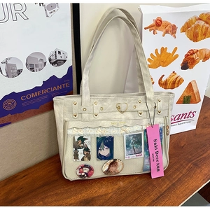 Macro shot of ita bag with clear PVC window, heart studs, and lace detailing