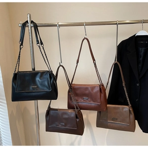 Detailansicht von Vintage-Ledertaschen in verschiedenen Farben an einem Verkaufsregal