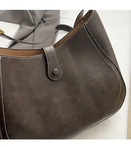 Macro detail of dark brown matte leather handbag with white stitching and PANTOOR logo