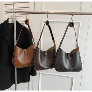 Detailed view of retro faux leather hobo bags in brown and gray with Pantone embossed logo