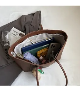 Detail view of large brown leather tote interior with spacious storage and zippered pocket