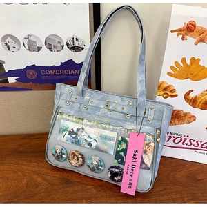 Detail view of light blue ita bag with transparent PVC window and gold heart buckle