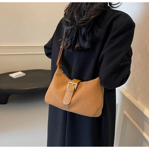 Detail view of brown suede underarm bag with silver buckle and contrast stitching