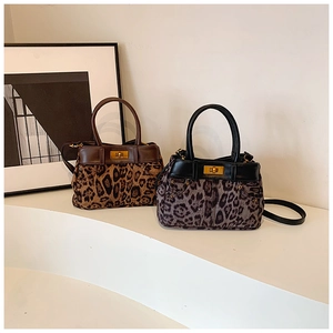 Detail view of leopard print handbags with gold twist locks and unique side pocket accents