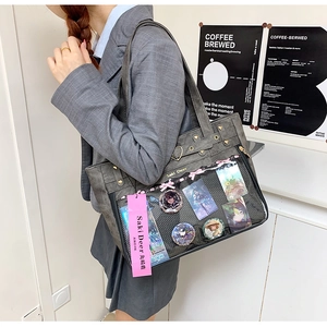 Detail of grey Oxford tote bag featuring a clear PVC window for anime badge display