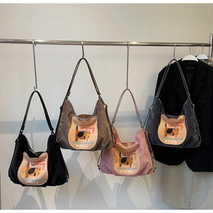 Detail of four colorful corduroy tote bags with cute cat embroidery on metal hangers