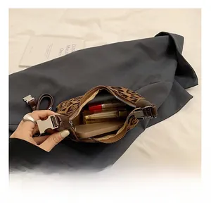 Detailed interior of leopard print crossbody bag showing phone and lipstick storage