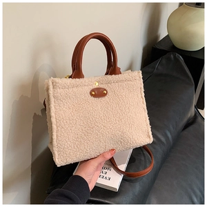 Detail der flauschigen Tasche mit Leder-Patch und Griffen in gemütlichem Ambiente