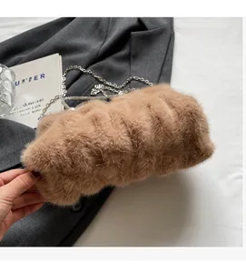 Détail du sac à main en fausse fourrure marron avec fermoir perle et chaîne argentée