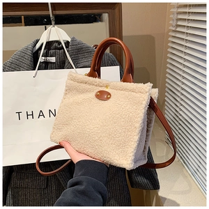 Detailaufnahme der flauschigen Plüschtasche mit braunen Ledergriffen und Schultergurt