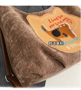 Detailed view of brown corduroy fabric with cute cat embroidery and heart pattern