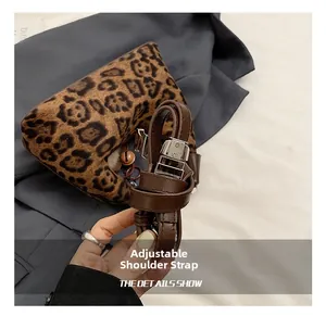 Detail of adjustable brown leather strap and leopard print faux fur texture on a handbag