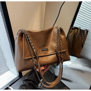 Detail der braunen Vintage-Tasche mit Metallketten-Riemen und Logo-Plakette aus Metall