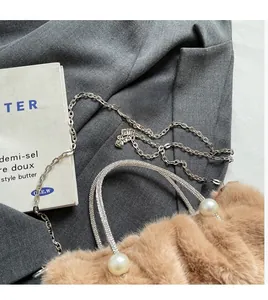 Gros plan du sac à main pelucheux camel avec poignées en diamants et perles