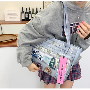 Macro shot of large transparent window on light blue tote bag showing anime badges