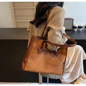 Brown bow tote bag with contrast matte and shiny leather textures shown in lifestyle setting