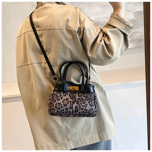 Close-up of leopard print handbag with metallic turn-lock and leather shoulder strap