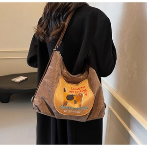 Detailed back view of a brown corduroy tote bag with cat embroidery and adjustable strap