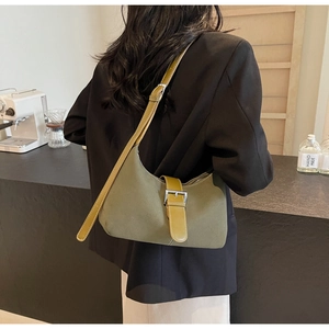 Detail view of olive green hobo bag with contrast yellow strap and silver metal buckle