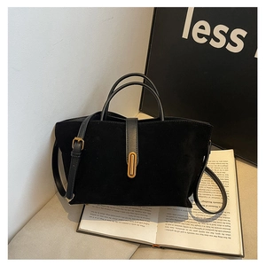 Close-up of black suede tote bag with leather straps and metallic buckle detail