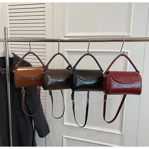 Detail of vintage square handbags in brown, black, and burgundy with embossed logos