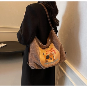 Detail of brown corduroy tote bag featuring cat embroidery and large capacity strap