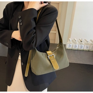 Detail of dark green crescent shoulder bag with brown leather buckle strap and matte finish