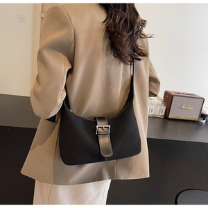 Detail of black crescent shoulder bag featuring premium leather and silver buckle closure