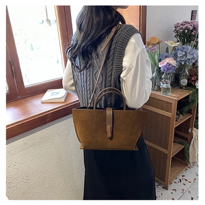 Brown frosted leather tote bag with shoulder strap shown in a vintage interior scene