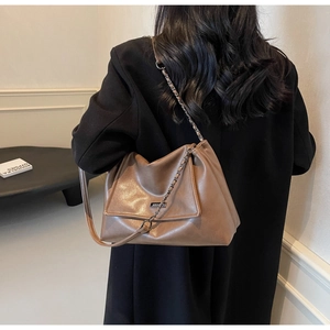Detail der minimalistischen dunkelbraunen Ledertasche mit Kettenriemen und Klappverschluss