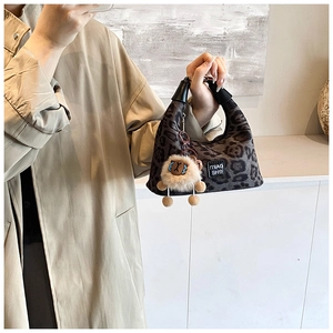 Detail of grey leopard print hobo bag with leather handle and plush sheep charm