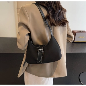 Detail view of black moon bag with white contrast stitching and silver buckle on model