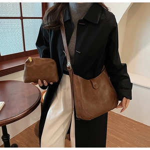 Close-up of vintage brown leather bucket bag and matching small pouch with fine texture