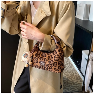 Chic leopard print hobo bag with dark brown handles and cute white alpaca charm
