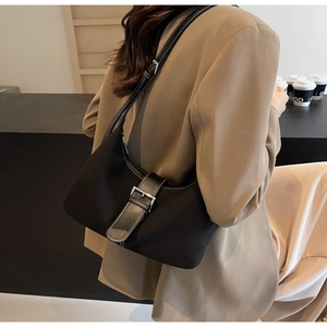 Detail of black underarm bag featuring white contrast stitching and metal buckle closure