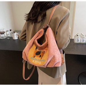 Detail of orange-pink corduroy backpack with cute cat embroidery and leather strap