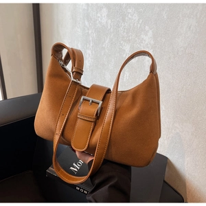 Macro view of brown suede texture and silver buckle detail on this elegant hobo shoulder bag