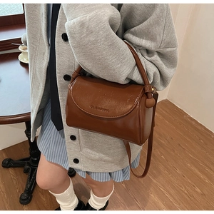 Brown vintage cylindrical shoulder bag with glossy synthetic leather and flap closure