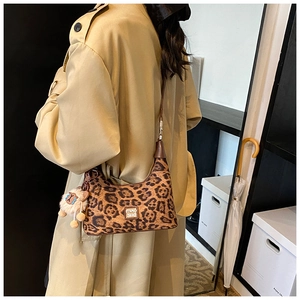 Detail of hobo bag with leopard print, brown shoulder strap and cute plush sheep charm