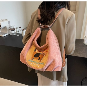 Pink corduroy backpack with yellow cat embroidery and brown leather straps