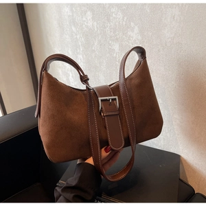 Close-up of brown suede hobo bag featuring contrast leather straps and silver metal buckle