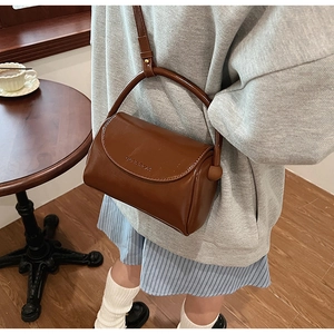 Brown leather crossbody bag featuring the CEBAROK embossed logo and top handle detail