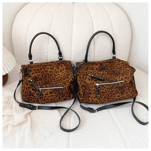 Détail du sac cabas léopard avec poignées en cuir noir et fermeture éclair argentée