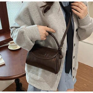 Close-up of dark brown vintage Boston bag showing premium matte texture and leather handle