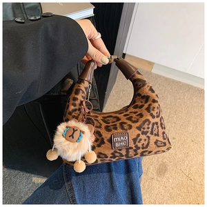 Detail view of stylish leopard print crossbody bag with cute plush sheep charm