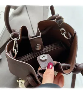 Details der braunen Leder-Eimertasche mit Reißverschlussfach und goldenem Magnetverschluss